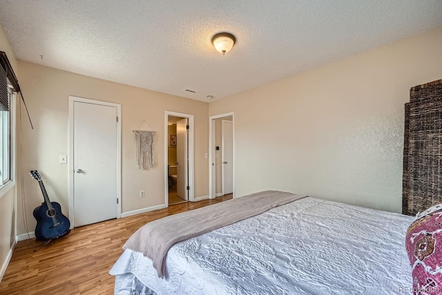 3050 W 32nd Ave Unit 202C, Denver, CO 80211 - bedroom featuring wood finished floors, a textured ceiling, and baseboards
