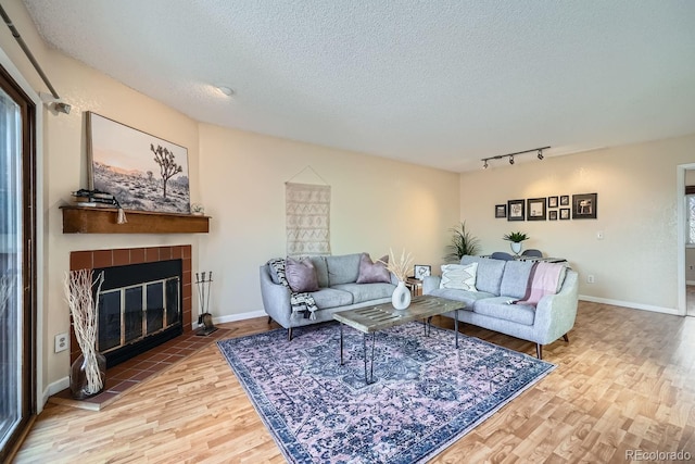 3050 W 32nd Ave Unit 202C, Denver, CO 80211 - living area with wood finished floors, track lighting, a textured ceiling, a fireplace, and baseboards