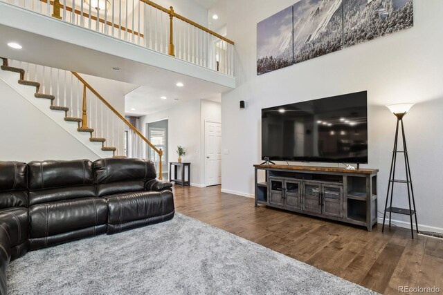 19653 E Ida Dr, Aurora, CO 80015 - living area with wood finished floors, stairs, and a towering ceiling