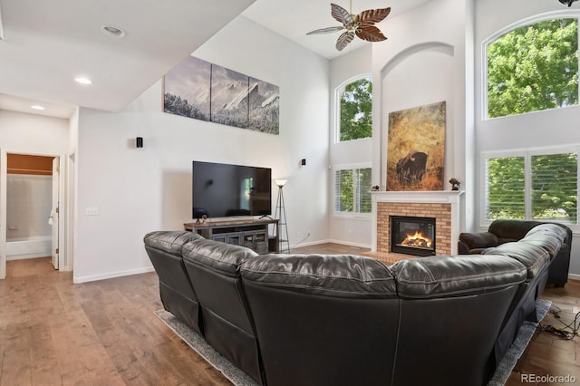 19653 E Ida Dr, Aurora, CO 80015 - living area featuring a towering ceiling, a fireplace, hardwood / wood-style floors, a ceiling fan, and recessed lighting