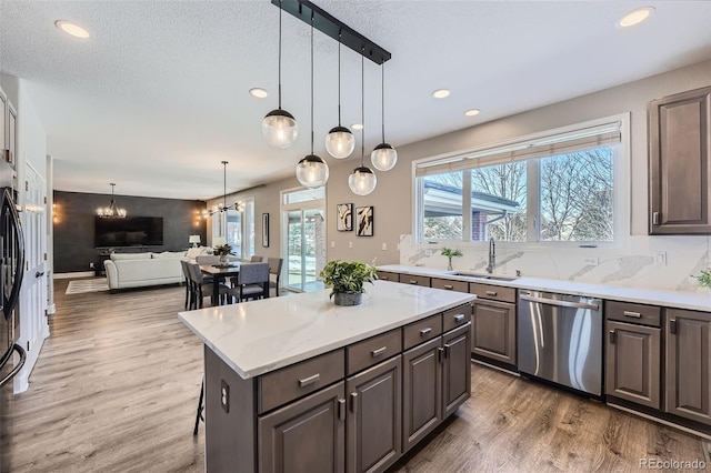 kitchen featuring sink, dark brown cabinets, a center island, and appliances with stainless steel finishes