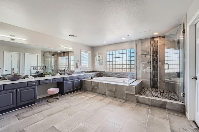 bathroom featuring vanity, shower with separate bathtub, and a textured ceiling