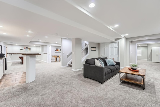 living room with recessed lighting, light colored carpet, and stairs