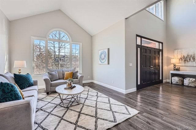 living area with high vaulted ceiling, wood finished floors, and baseboards