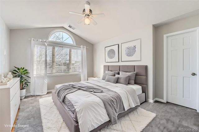 carpeted bedroom with baseboards, ceiling fan, visible vents, and vaulted ceiling