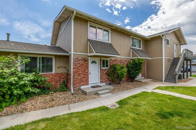 2232 Coronado Pkwy Unit B, Denver, CO 80229 - view of front of house with brick siding, a front lawn, stairs, and a shingled roof
