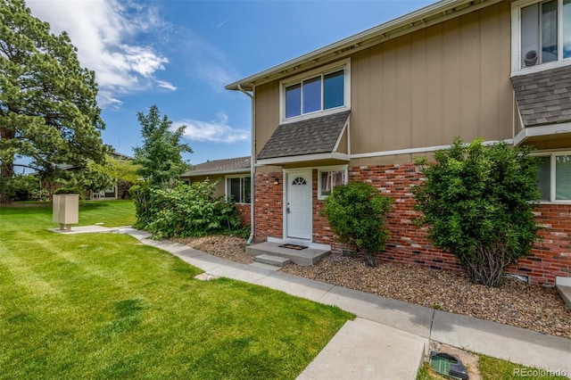 2232 Coronado Pkwy Unit B, Denver, CO 80229 - view of front facade with a front yard, brick siding, and a shingled roof