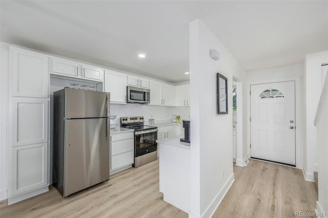 2232 Coronado Pkwy Unit B, Denver, CO 80229 - kitchen featuring appliances with stainless steel finishes, white cabinetry, light wood-style flooring, light countertops, and recessed lighting