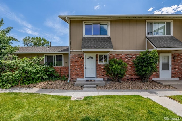 2232 Coronado Pkwy Unit B, Denver, CO 80229 - view of front of property with brick siding, a front yard, and roof with shingles