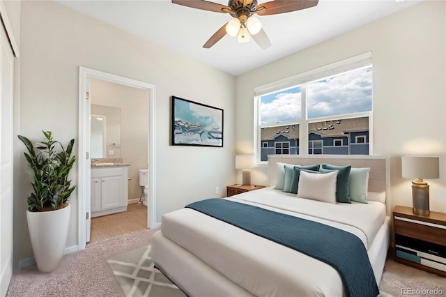 carpeted bedroom with ceiling fan and ensuite bathroom