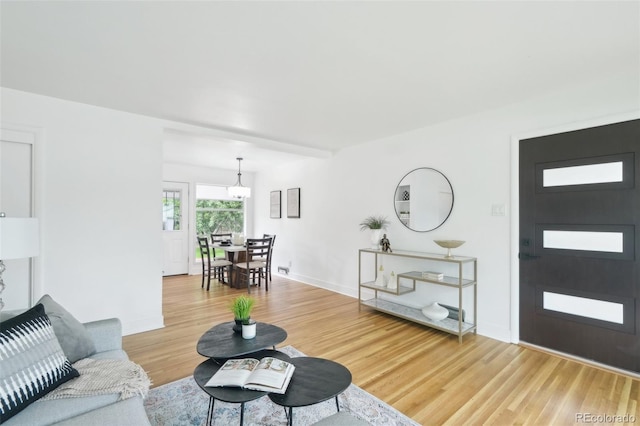 5445 Nebraska Way, Denver, CO 80246 - living room featuring light wood finished floors, a chandelier, and baseboards
