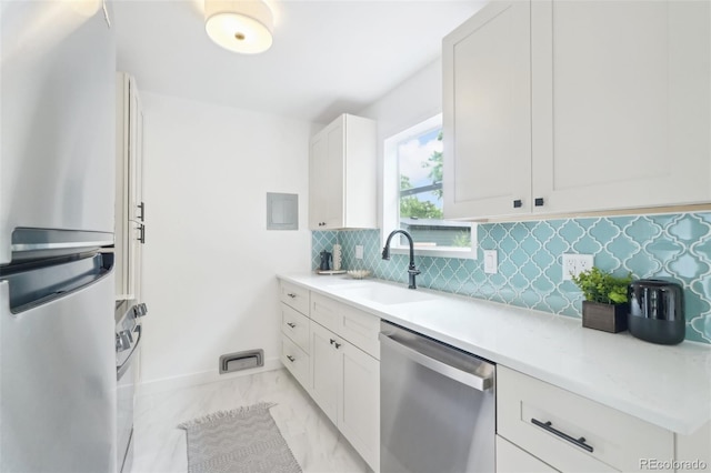 5445 Nebraska Way, Denver, CO 80246 - kitchen with stainless steel appliances, a sink, decorative backsplash, light marble finish flooring, and white cabinets