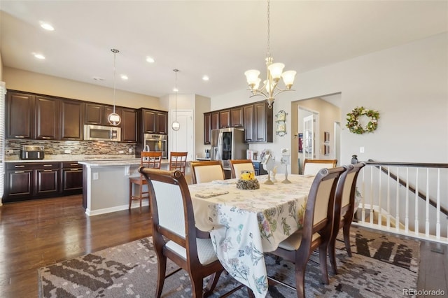 dining area with dark wood-style flooring, a chandelier, and recessed lighting