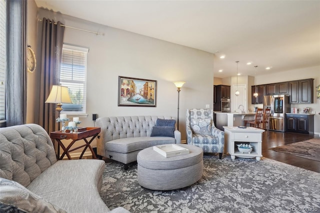 living area with dark wood-type flooring and recessed lighting