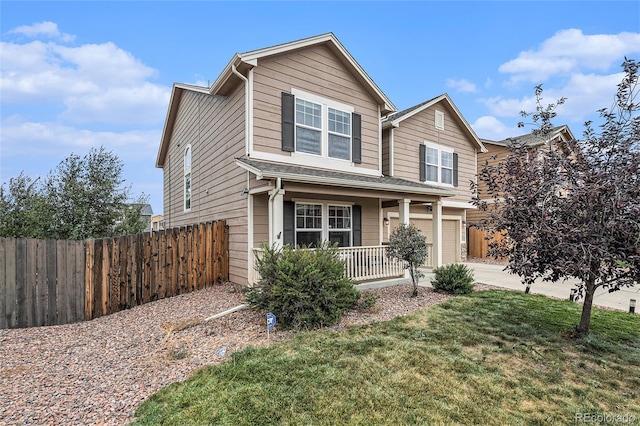 view of front of property featuring a garage, a front lawn, and covered porch