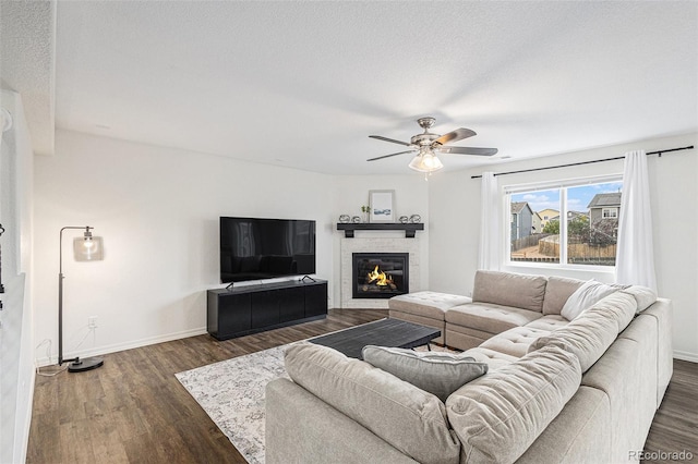 living room with ceiling fan, dark hardwood / wood-style floors, and a textured ceiling