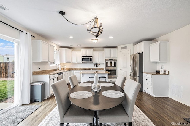 dining area featuring a notable chandelier, light hardwood / wood-style floors, and sink