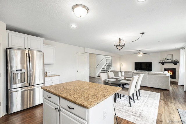 kitchen featuring white cabinetry, a center island, dark hardwood / wood-style floors, and stainless steel fridge with ice dispenser