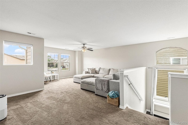 living room with ceiling fan, carpet, and a textured ceiling