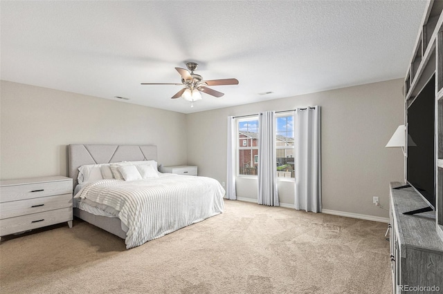 bedroom featuring ceiling fan, light colored carpet, and a textured ceiling