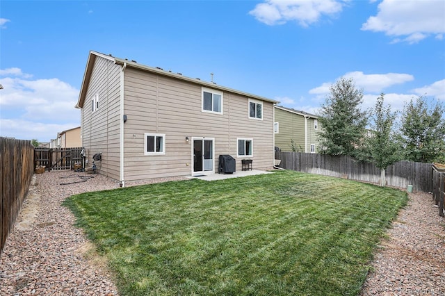 rear view of house featuring a yard and a patio area