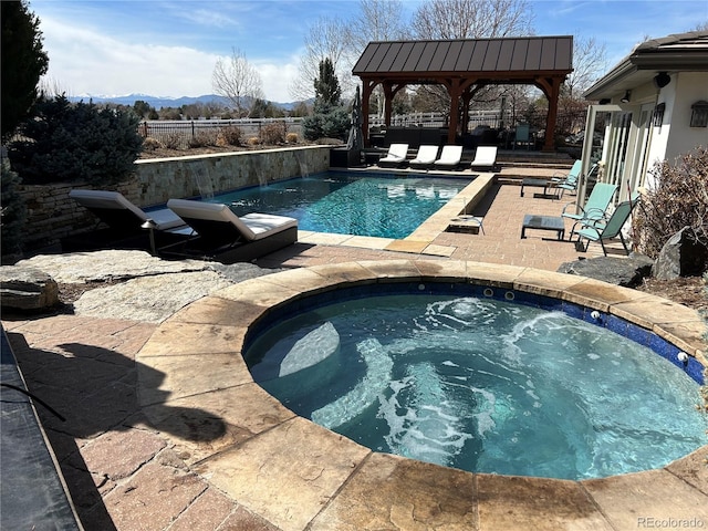 view of pool with a fenced in pool, fence, an in ground hot tub, a gazebo, and a patio area