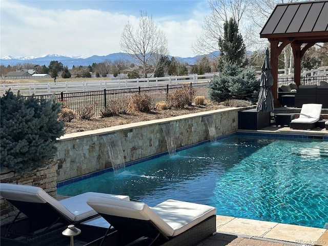 view of swimming pool with a fenced in pool, a mountain view, and a fenced backyard