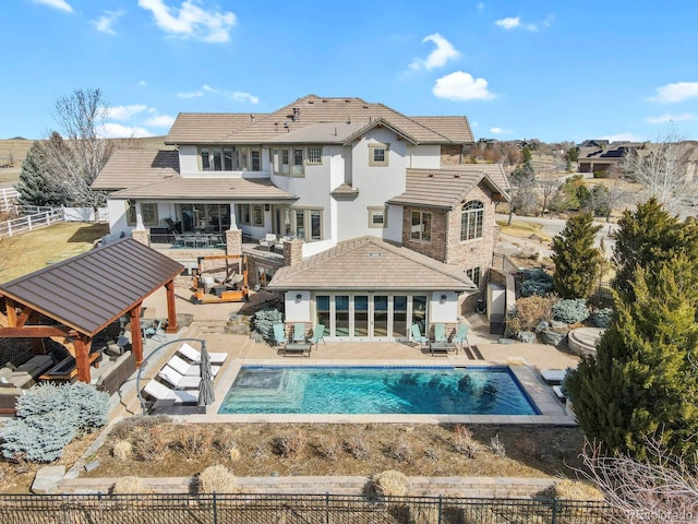 rear view of property featuring a patio area, a tile roof, and a fenced backyard