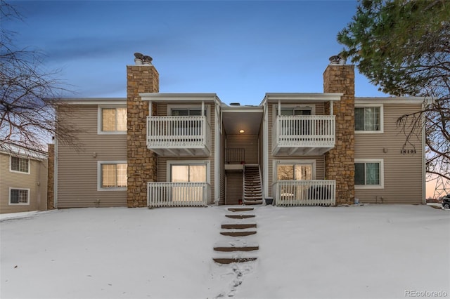 snow covered property with a balcony