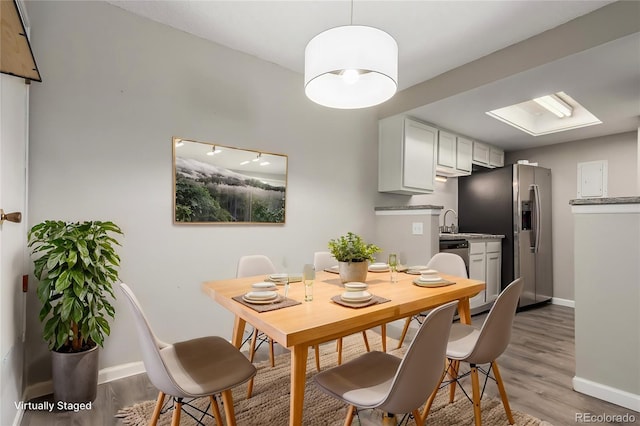 dining space with hardwood / wood-style floors and sink