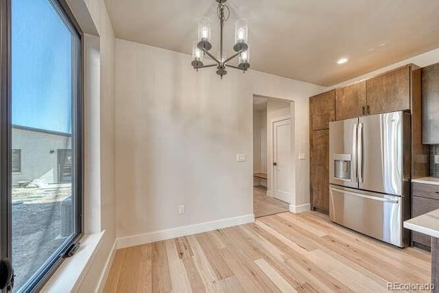 136 Chase St, Salida, CO 81201 - kitchen with stainless steel refrigerator with ice dispenser, light wood-type flooring, a chandelier, light countertops, and brown cabinets