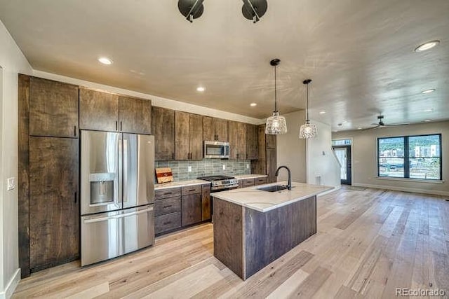 136 Chase St, Salida, CO 81201 - kitchen featuring stainless steel appliances, light wood-type flooring, ceiling fan, light countertops, and a kitchen island with sink