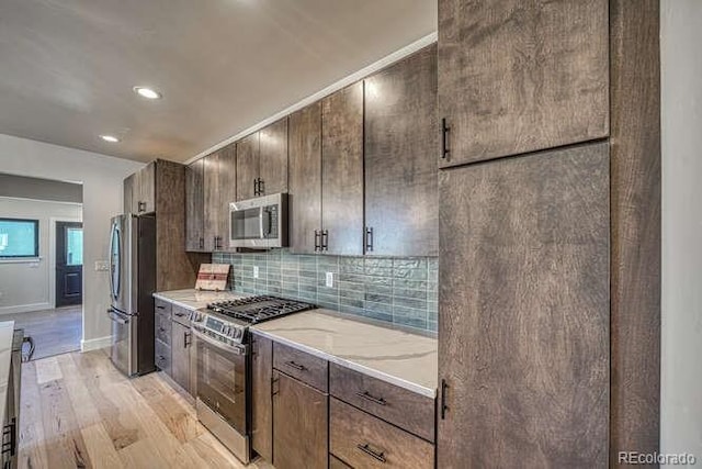136 Chase St, Salida, CO 81201 - kitchen with appliances with stainless steel finishes, light wood-style flooring, decorative backsplash, recessed lighting, and dark brown cabinetry