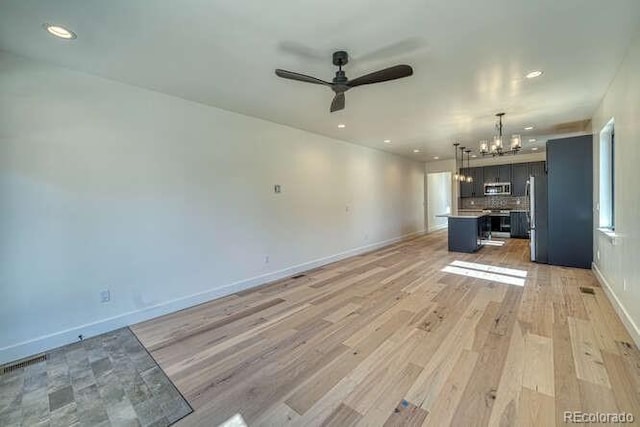 136 Chase St, Salida, CO 81201 - unfurnished living room featuring a chandelier, ceiling fan, recessed lighting, and light wood-style floors