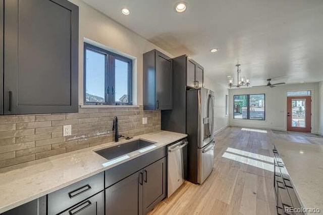 136 Chase St, Salida, CO 81201 - kitchen with stainless steel appliances, light wood finished floors, open floor plan, decorative backsplash, and a chandelier
