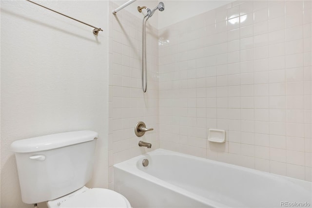 bathroom with toilet and tiled shower / bath combo