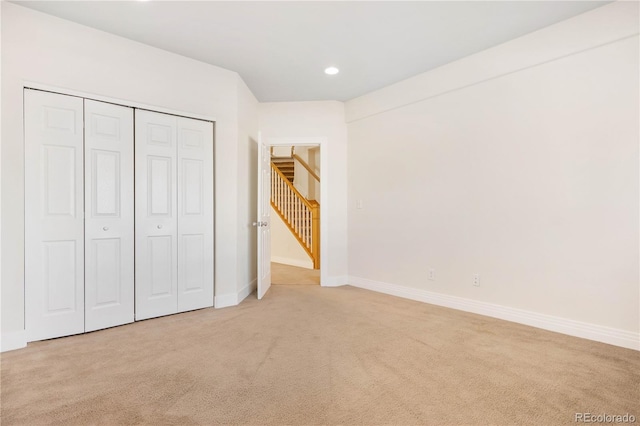 unfurnished bedroom featuring a closet and light colored carpet