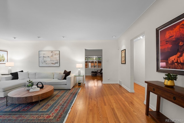 living area with light wood-style flooring and baseboards