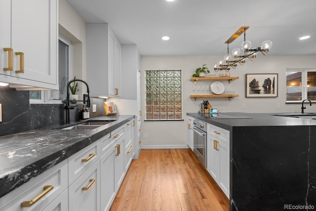 kitchen featuring a sink, light wood-style flooring, white cabinets, and recessed lighting