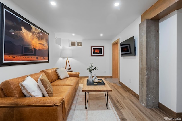 living area with light wood-type flooring, recessed lighting, and baseboards