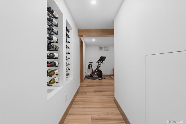 hall featuring light wood finished floors, recessed lighting, and baseboards