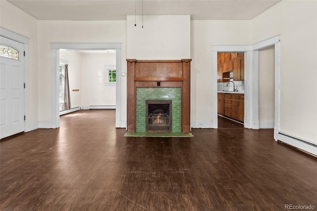 458 Cherry St, Hudson, CO 80642 - unfurnished living room featuring dark wood-style floors, a tile fireplace, and baseboard heating