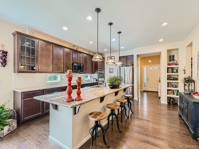 16658 Prospect Ln, Broomfield, CO 80023 - kitchen featuring appliances with stainless steel finishes, dark wood-type flooring, a kitchen bar, dark brown cabinets, and glass insert cabinets