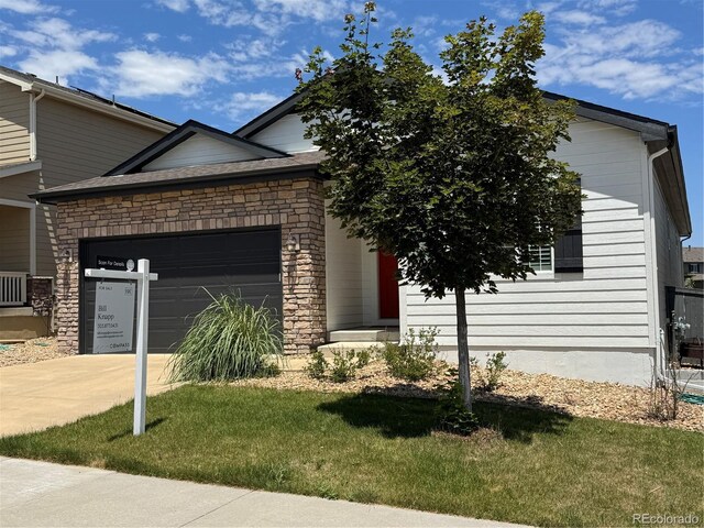 4391 Mcmurdo Ct, Castle Rock, CO 80108 - view of front of home with a garage, driveway, a front lawn, and stone siding