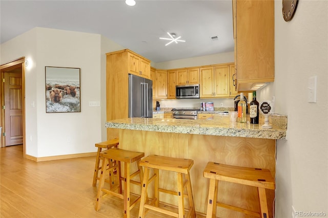 147 Forest Trl Unit 3, Winter Park, CO 80482 - kitchen featuring high end appliances, a peninsula, light wood finished floors, light stone counters, and recessed lighting