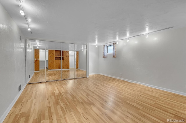 unfurnished room featuring light hardwood / wood-style flooring and track lighting