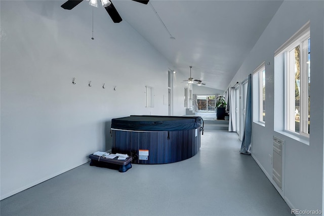 interior space with ceiling fan, a wealth of natural light, and lofted ceiling