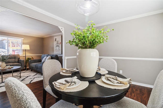 dining room with dark hardwood / wood-style floors and crown molding