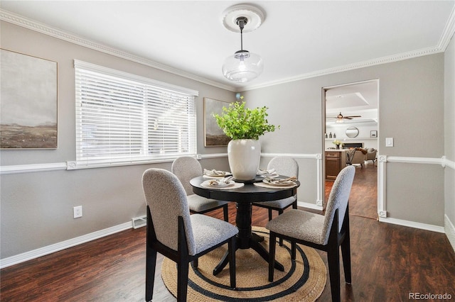 dining area featuring ceiling fan, dark wood-type flooring, and crown molding