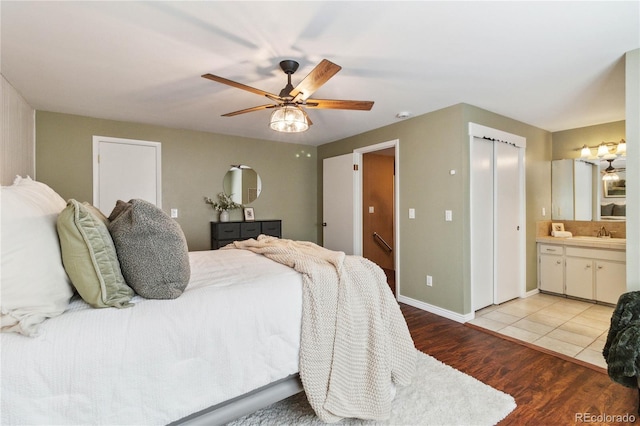 bedroom featuring ensuite bathroom, ceiling fan, sink, and light hardwood / wood-style floors